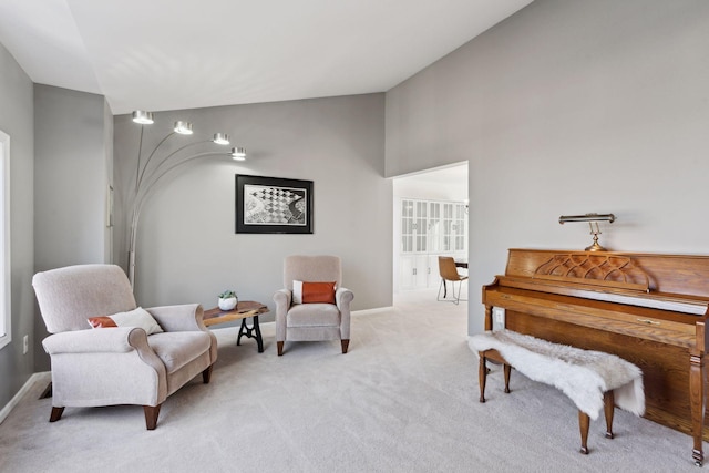 living area featuring high vaulted ceiling and light colored carpet