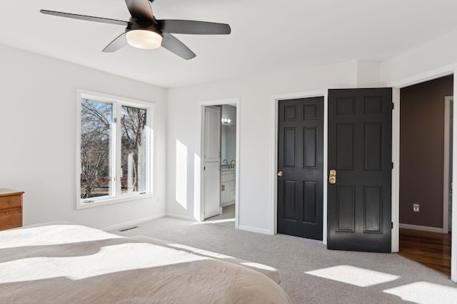 unfurnished bedroom with ensuite bathroom, light colored carpet, and ceiling fan