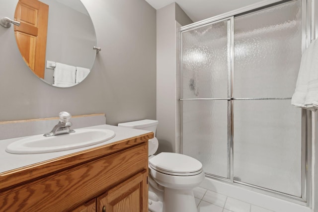 bathroom featuring tile patterned floors, vanity, toilet, and a shower with shower door