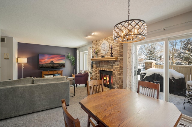 carpeted dining room with a fireplace, a wealth of natural light, and a textured ceiling