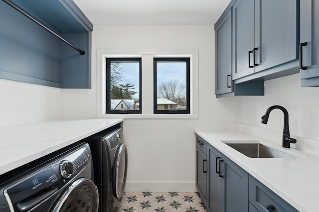 laundry room featuring light tile patterned floors, sink, washing machine and clothes dryer, and cabinets