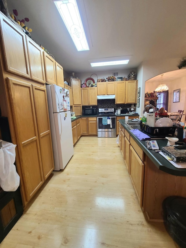 kitchen featuring backsplash, white fridge, pendant lighting, light hardwood / wood-style floors, and stainless steel electric range