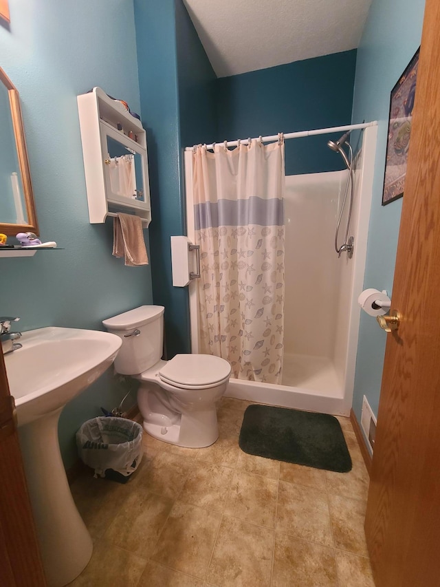 bathroom with toilet, sink, and a shower with shower curtain