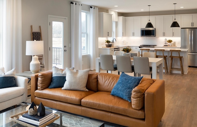 living area with light wood finished floors and recessed lighting