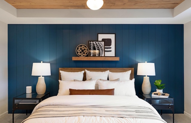 bedroom featuring wood ceiling, baseboards, and carpet flooring