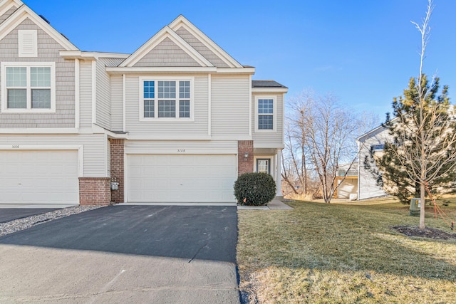 multi unit property featuring a garage, aphalt driveway, a front lawn, and brick siding