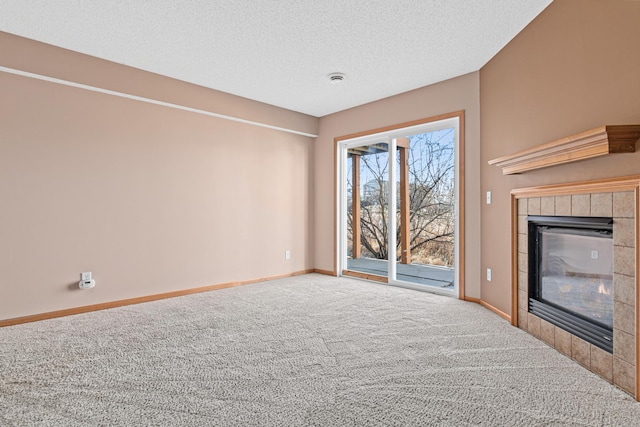 unfurnished living room featuring carpet, a fireplace, a textured ceiling, and baseboards