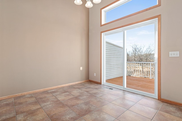 spare room with an inviting chandelier, baseboards, and visible vents