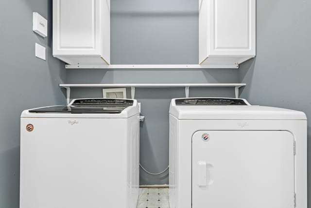 clothes washing area featuring cabinet space, washing machine and clothes dryer, and tile patterned floors