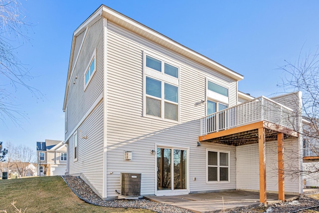 rear view of property with a patio area, cooling unit, and a lawn