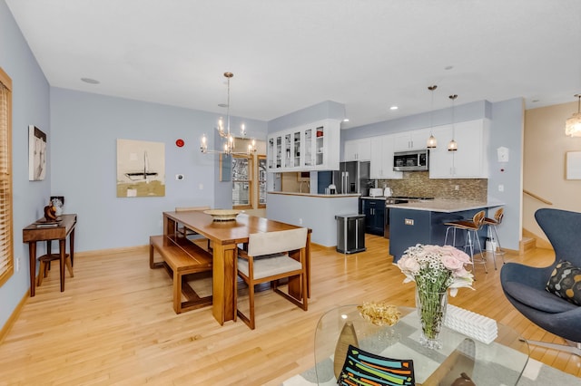 dining room featuring light wood-type flooring and a notable chandelier