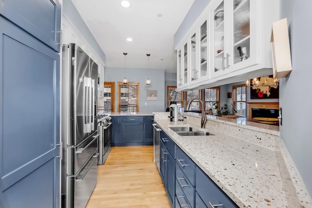 kitchen featuring white cabinetry, appliances with stainless steel finishes, sink, and pendant lighting