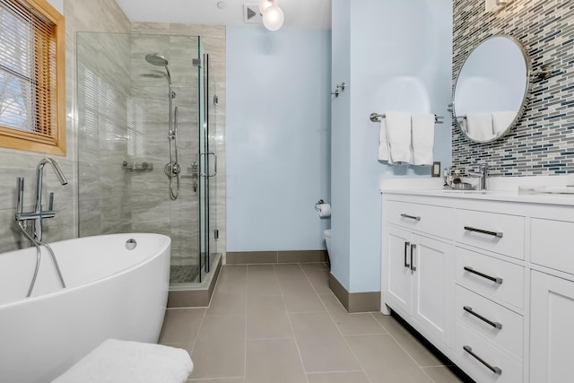 full bathroom featuring tile patterned flooring, backsplash, vanity, shower with separate bathtub, and toilet