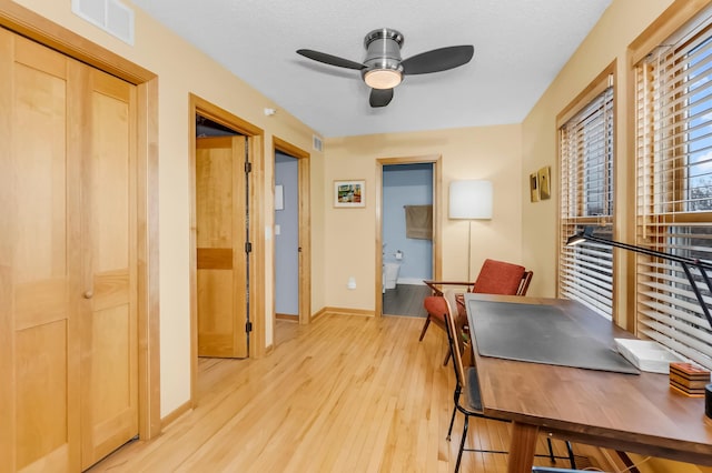 office with ceiling fan, a textured ceiling, and light wood-type flooring