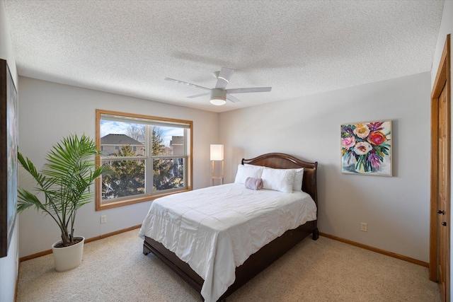 bedroom featuring light colored carpet, ceiling fan, a textured ceiling, and baseboards