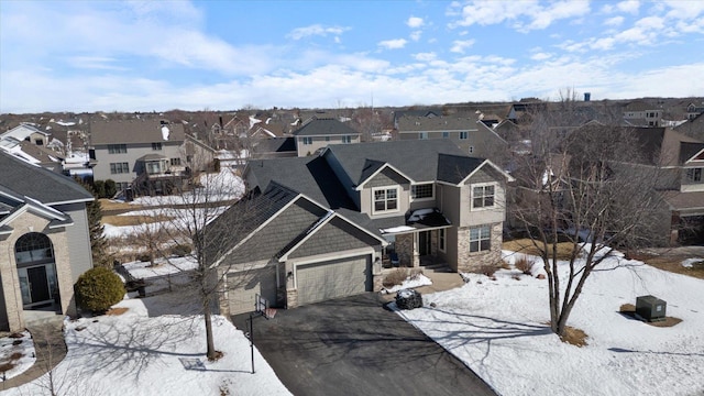 view of front of home featuring a garage, a residential view, stone siding, and driveway