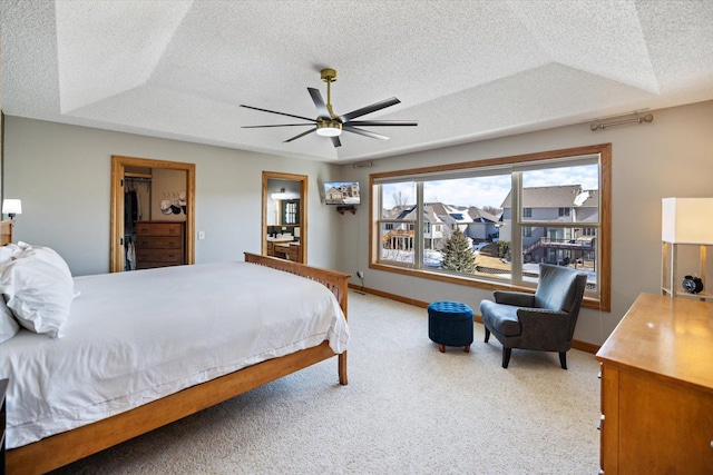 bedroom featuring a raised ceiling, carpet flooring, a textured ceiling, and baseboards