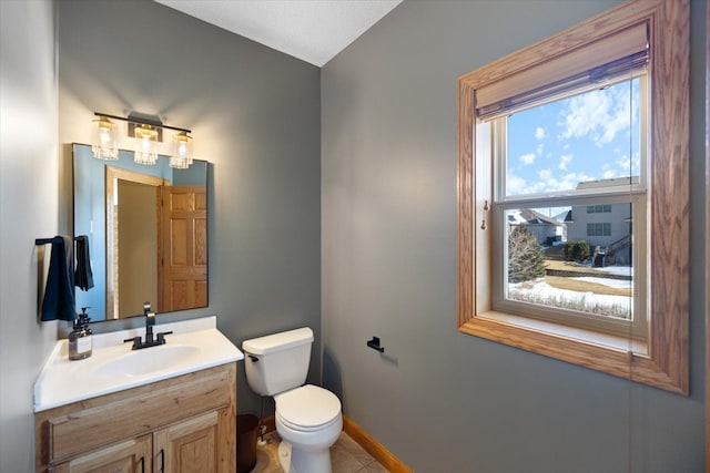 bathroom with tile patterned flooring, vanity, toilet, and baseboards