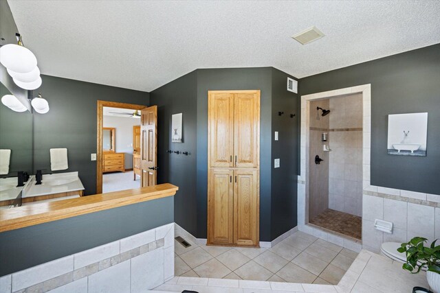 bathroom with visible vents, a tile shower, a textured ceiling, and tile patterned floors