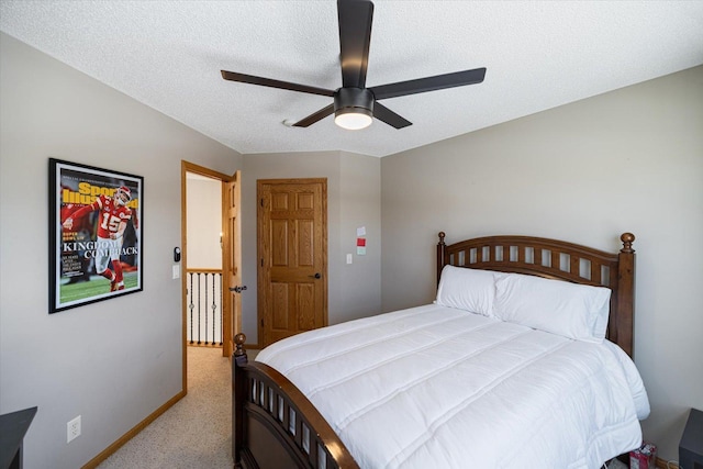 bedroom with a textured ceiling, baseboards, a ceiling fan, and light colored carpet