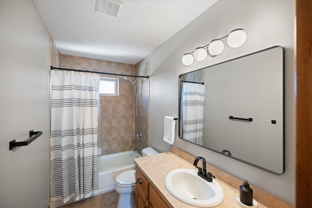 bathroom featuring visible vents, toilet, vanity, shower / bath combination with curtain, and a textured ceiling