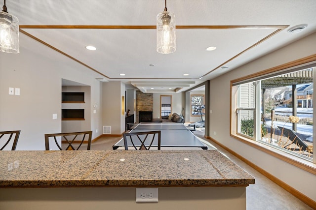 kitchen with decorative light fixtures, light carpet, a fireplace, and visible vents