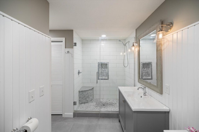 full bathroom featuring a closet, a shower stall, vanity, and tile patterned floors