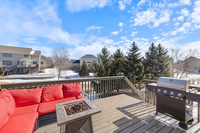 wooden terrace featuring a grill and an outdoor living space with a fire pit