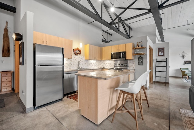 kitchen with pendant lighting, tasteful backsplash, light brown cabinets, and appliances with stainless steel finishes