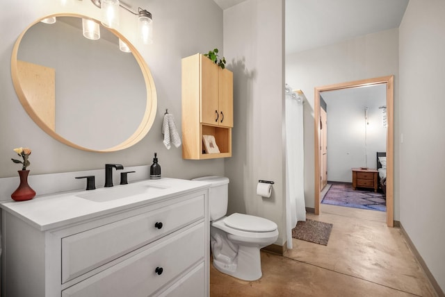 bathroom with vanity, concrete floors, and toilet