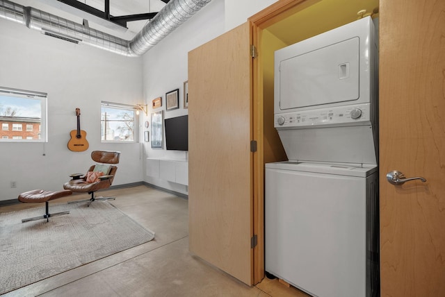 clothes washing area featuring stacked washer / dryer