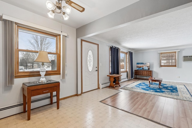 entryway with ceiling fan, baseboard heating, and a healthy amount of sunlight