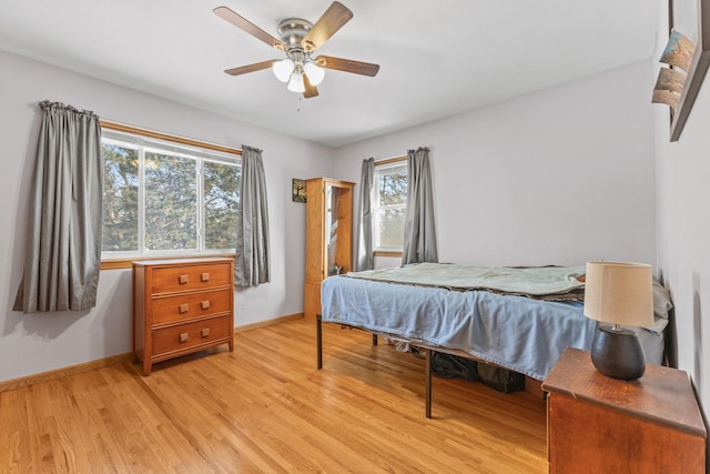 bedroom with ceiling fan, light hardwood / wood-style floors, and multiple windows