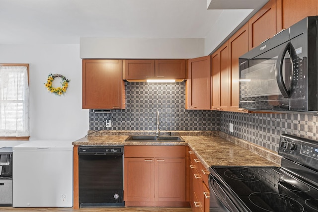 kitchen with black appliances, decorative backsplash, sink, and light stone counters