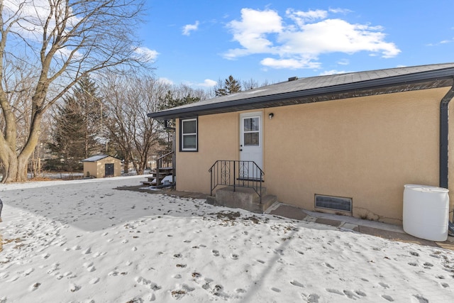 snow covered property featuring a storage unit