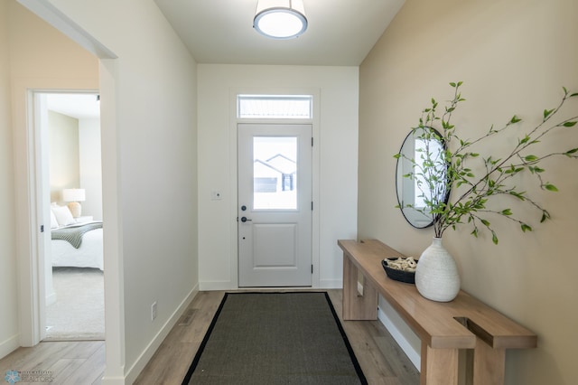 entryway with light wood finished floors and baseboards