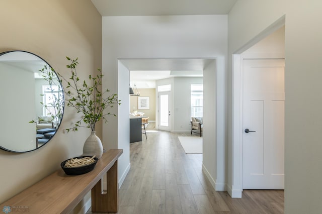 hallway with light wood-style flooring and baseboards