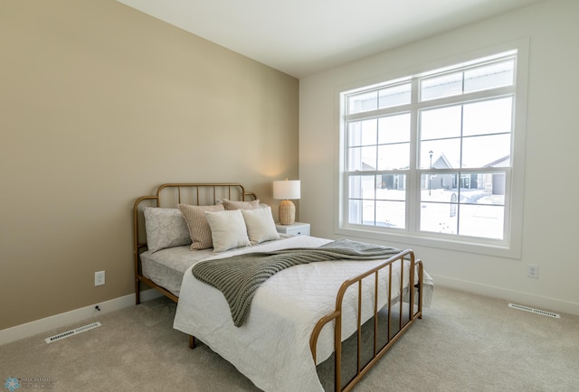 carpeted bedroom with visible vents and baseboards