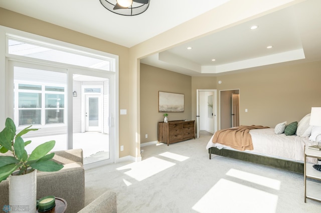 bedroom featuring access to exterior, recessed lighting, a raised ceiling, light colored carpet, and baseboards