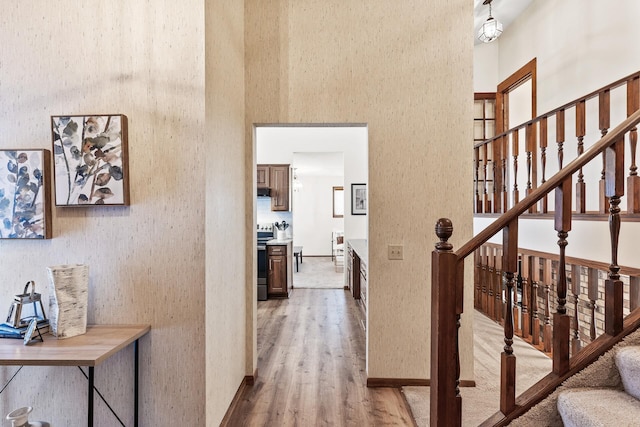 hallway featuring hardwood / wood-style flooring and a high ceiling