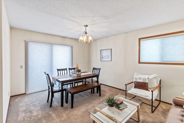 dining area featuring light carpet, a notable chandelier, and a textured ceiling