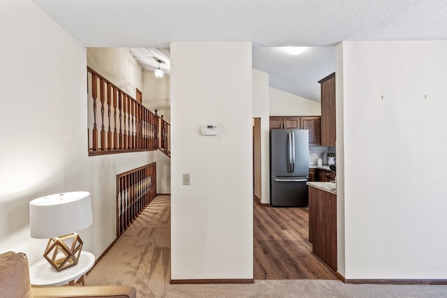 hall with carpet flooring and a textured ceiling