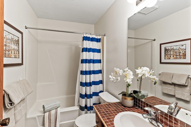 full bathroom featuring vanity, shower / bath combination with curtain, a textured ceiling, and toilet