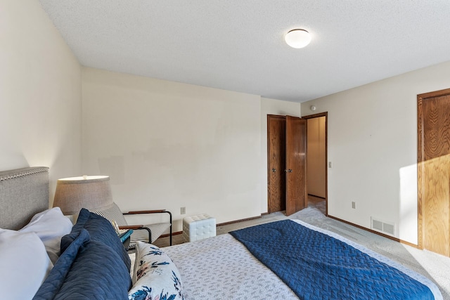 bedroom featuring light colored carpet and a textured ceiling