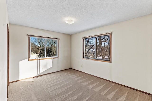 carpeted spare room with a textured ceiling