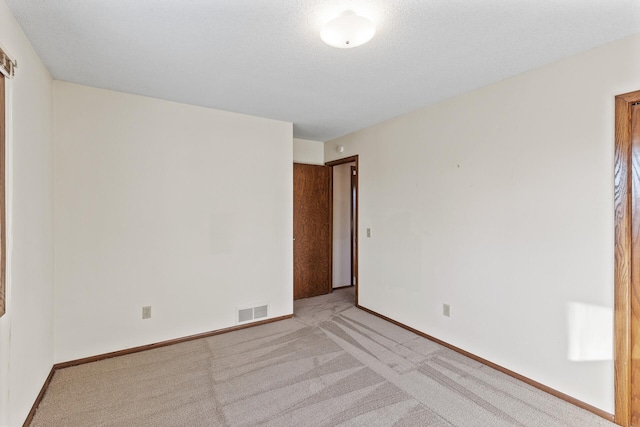 carpeted empty room with a textured ceiling