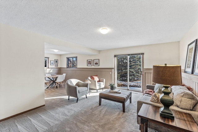 living room featuring a healthy amount of sunlight, light colored carpet, and a textured ceiling