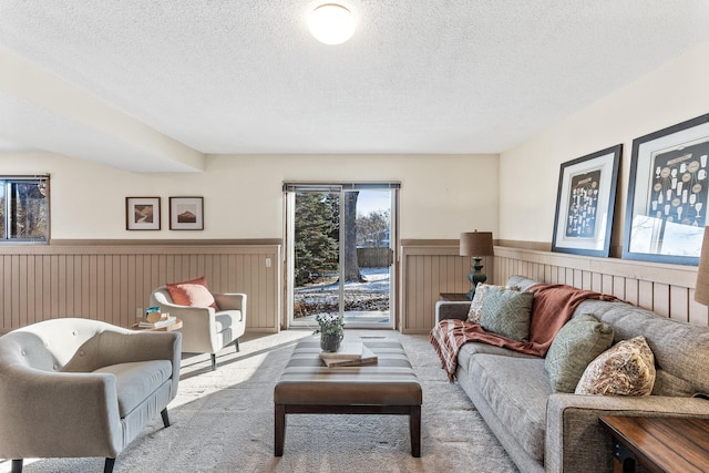 carpeted living room featuring a textured ceiling and wood walls