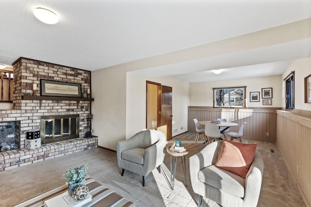 living room featuring light colored carpet, a fireplace, and a textured ceiling