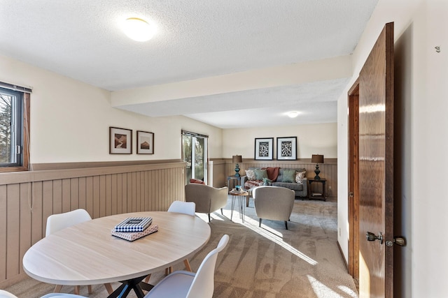 carpeted dining space featuring a textured ceiling